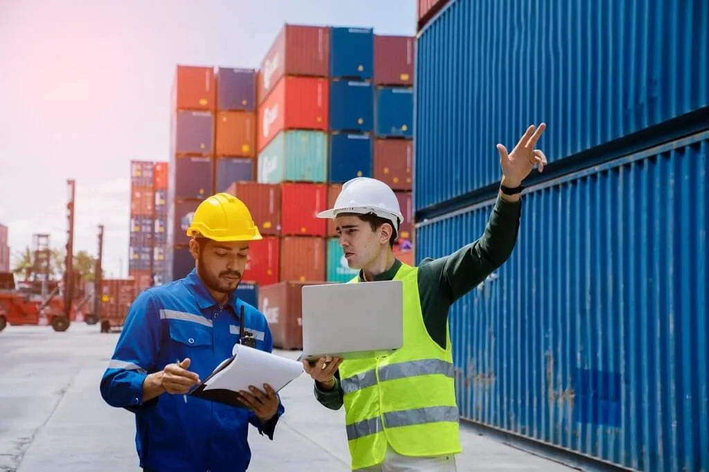 Two professionals monitoring supply chain management operations, logistics performance, and business workflow efficiency
