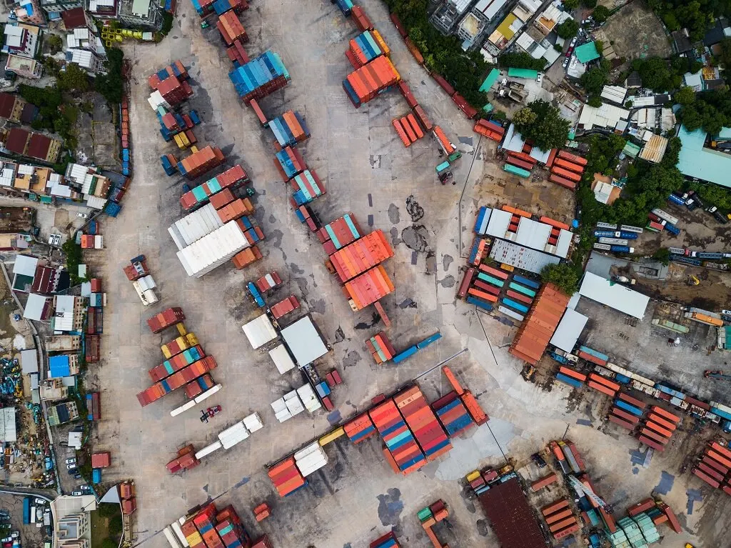 Aerial view of shipping containers at an urban port supporting project logistics in Southeast Asia.